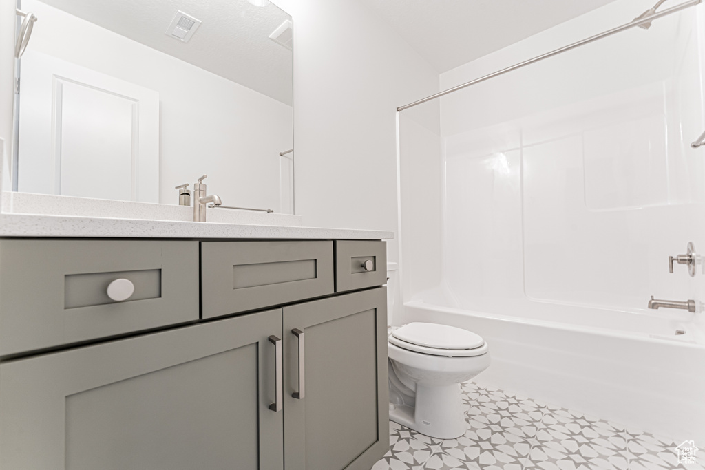 Bathroom with toilet, vanity, and washtub / shower combination