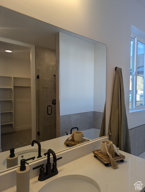 Bathroom featuring sink, a wealth of natural light, and walk in shower