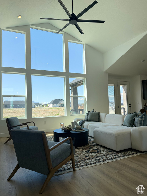 Living area featuring high vaulted ceiling, ceiling fan, and wood finished floors