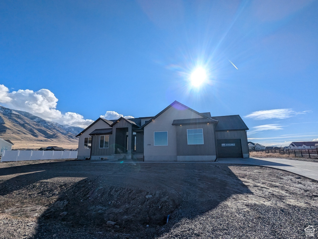 View of front of home with a mountain view and a garage