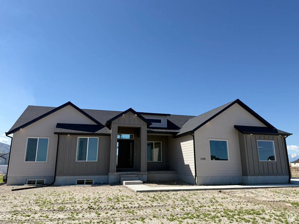 View of front of property with roof with shingles and board and batten siding