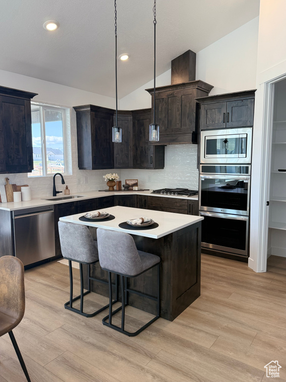 Kitchen with light wood-style floors, a sink, light countertops, and stainless steel appliances