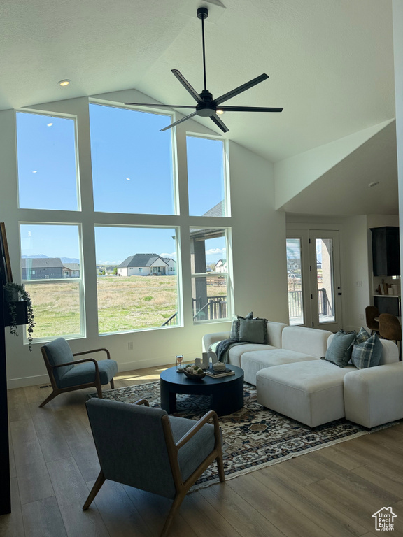 Living room featuring a ceiling fan, wood finished floors, and high vaulted ceiling