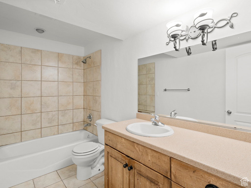 Full bathroom featuring tile patterned floors, vanity, tiled shower / bath combo, and toilet