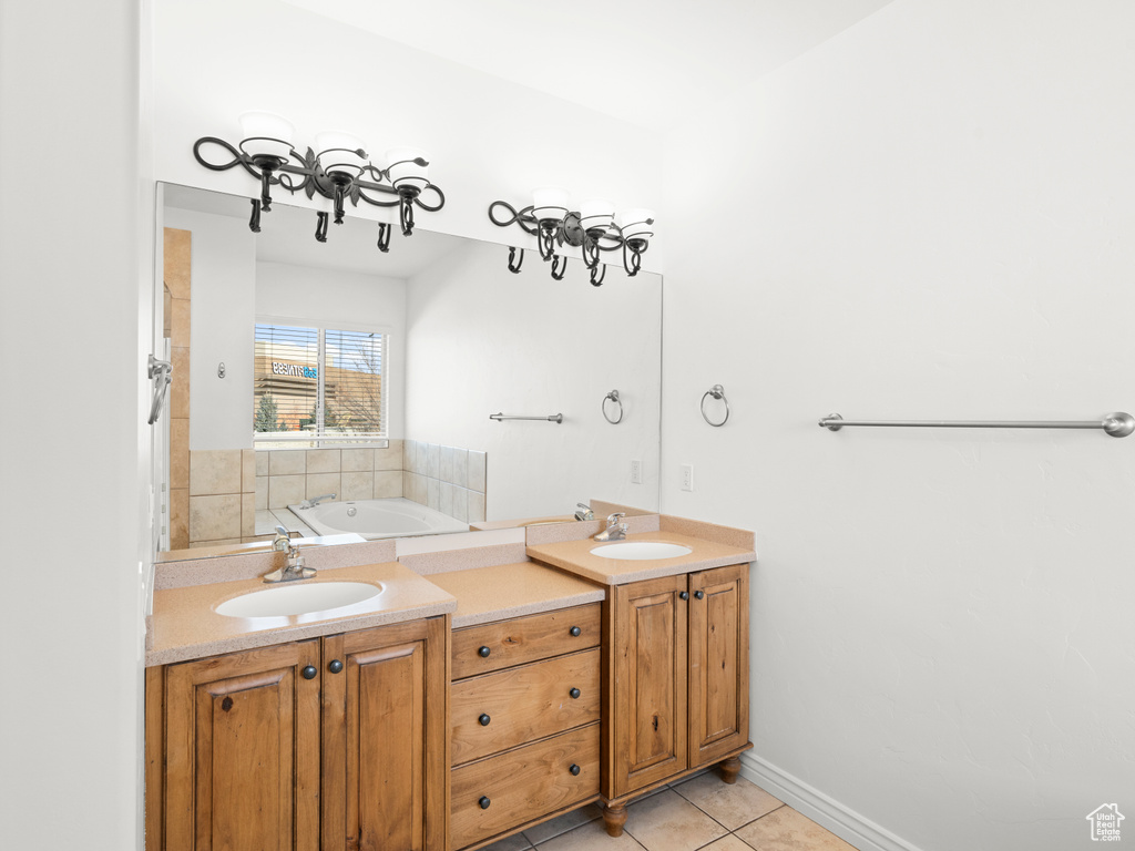 Bathroom featuring tile patterned flooring, vanity, and a bath