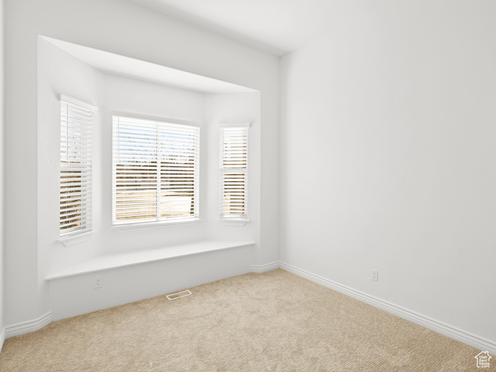 Empty room featuring light colored carpet