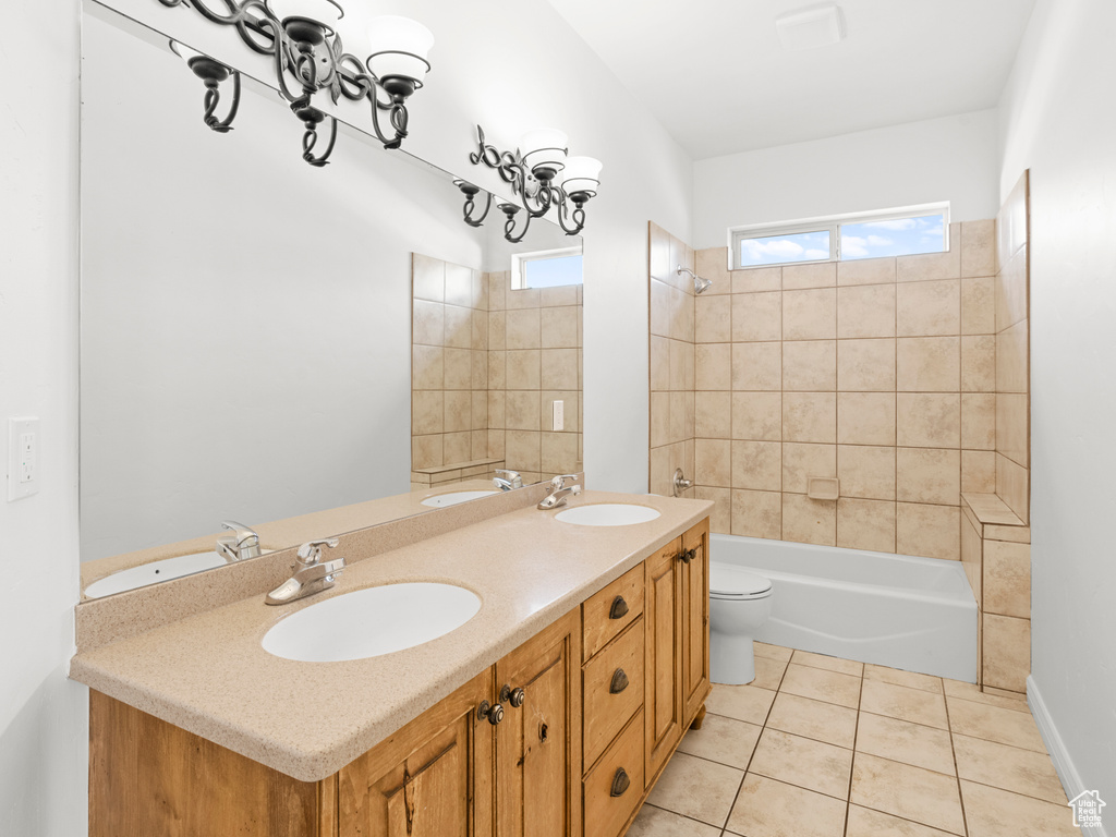 Full bathroom featuring tile patterned floors, vanity, tiled shower / bath combo, and toilet