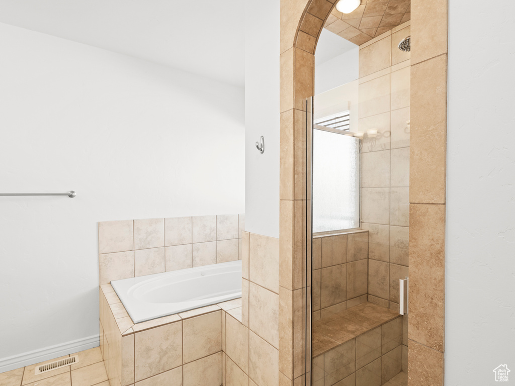 Bathroom featuring tile patterned flooring and independent shower and bath