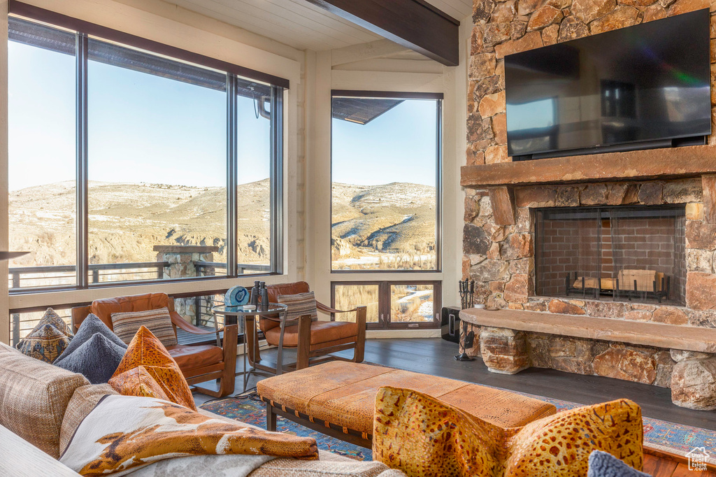 Living room featuring a fireplace, wood-type flooring, and a wealth of natural light