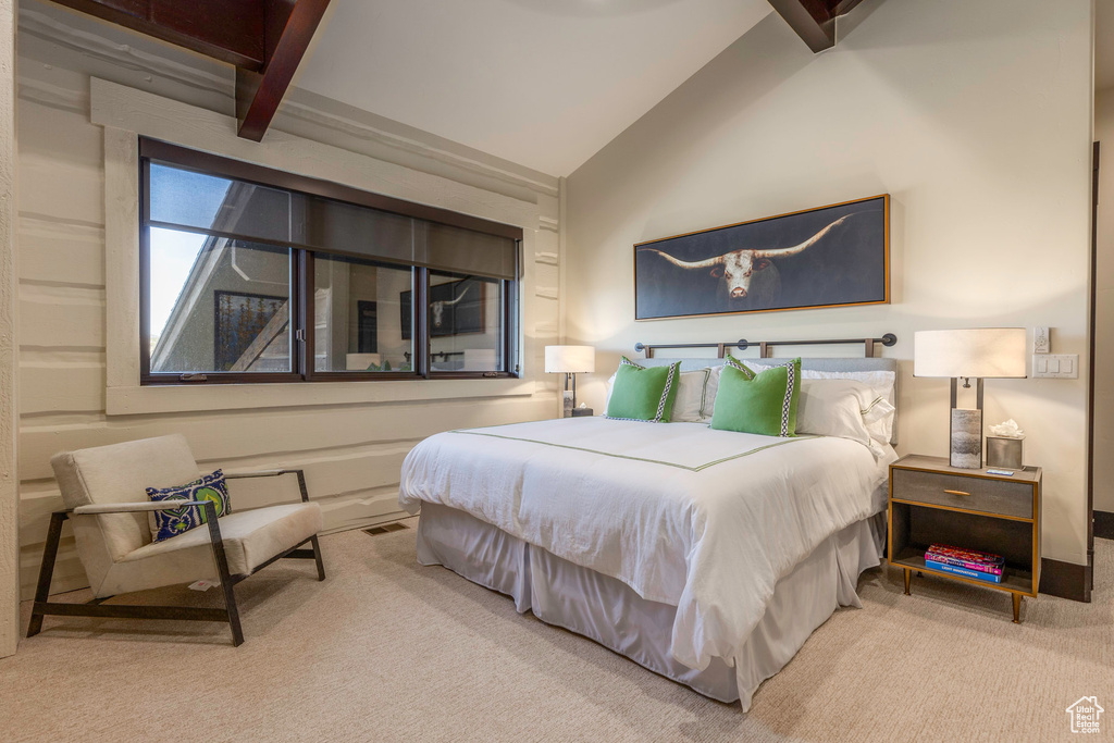 Carpeted bedroom with lofted ceiling with beams