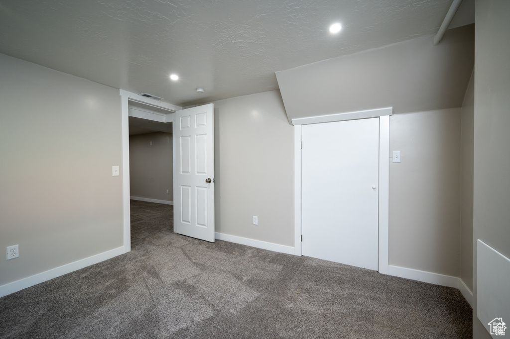 Interior space featuring carpet flooring and a textured ceiling