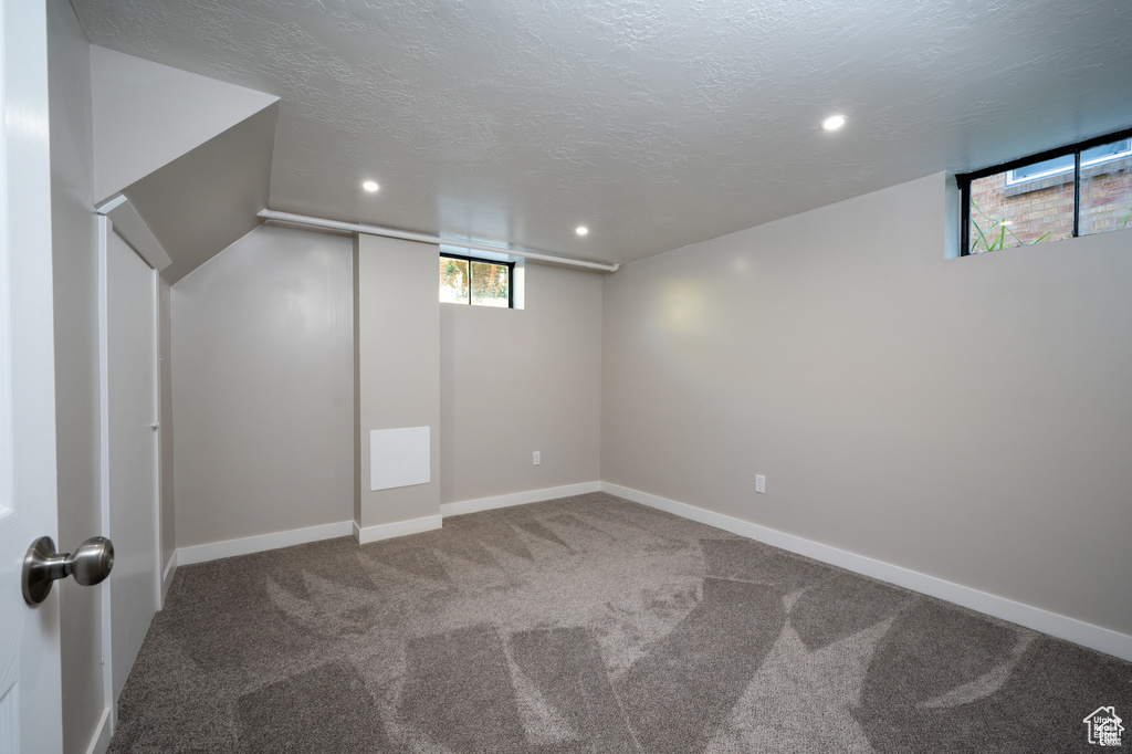 Basement with carpet and a textured ceiling