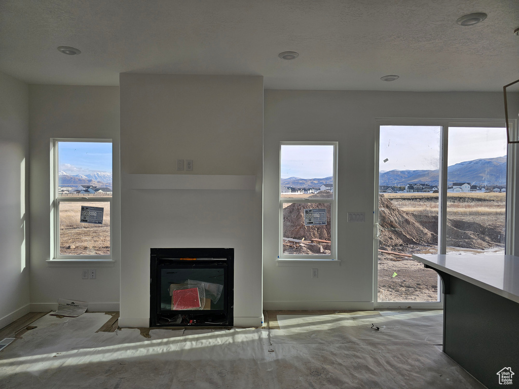 Unfurnished living room featuring a mountain view and a healthy amount of sunlight