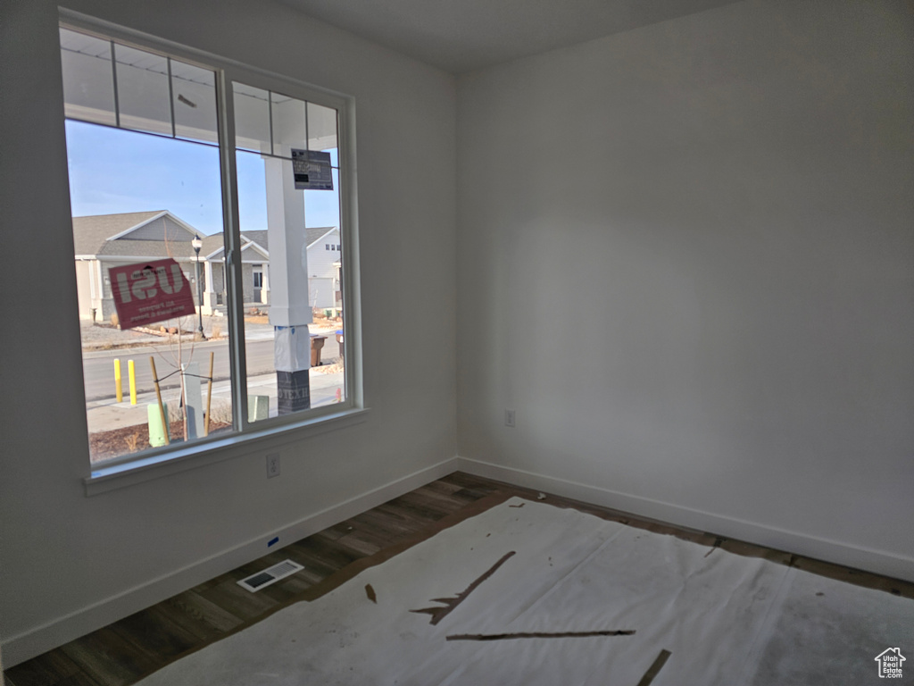 Unfurnished room with a wealth of natural light and hardwood / wood-style flooring