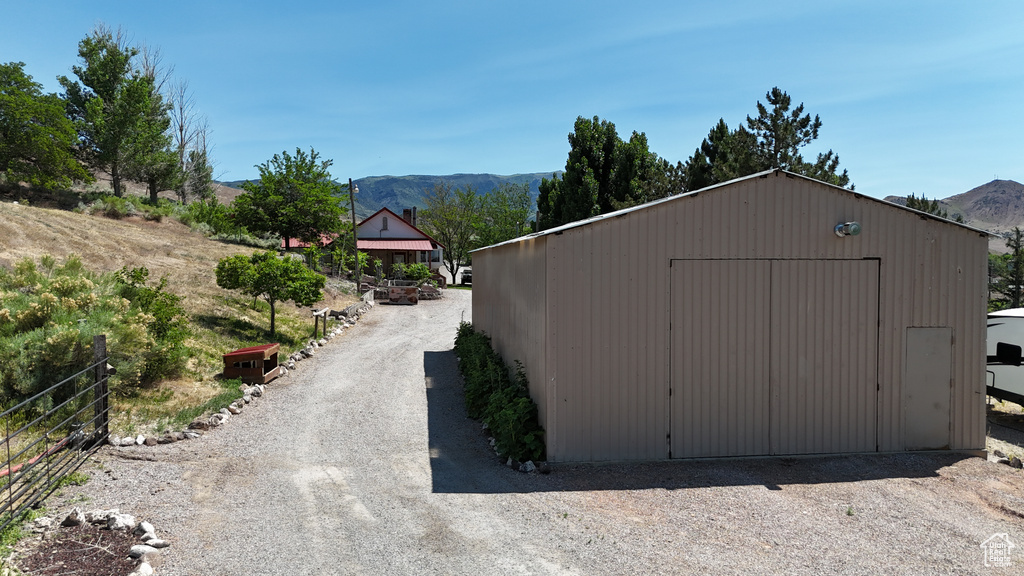 View of outdoor structure featuring a mountain view and gravel driveway