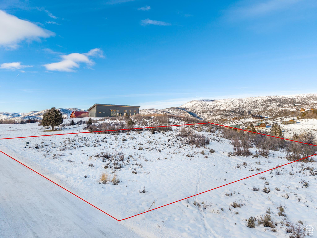 Yard covered in snow with a mountain view