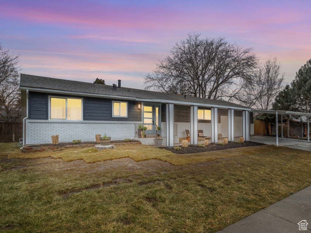 Ranch-style house featuring a yard and a carport