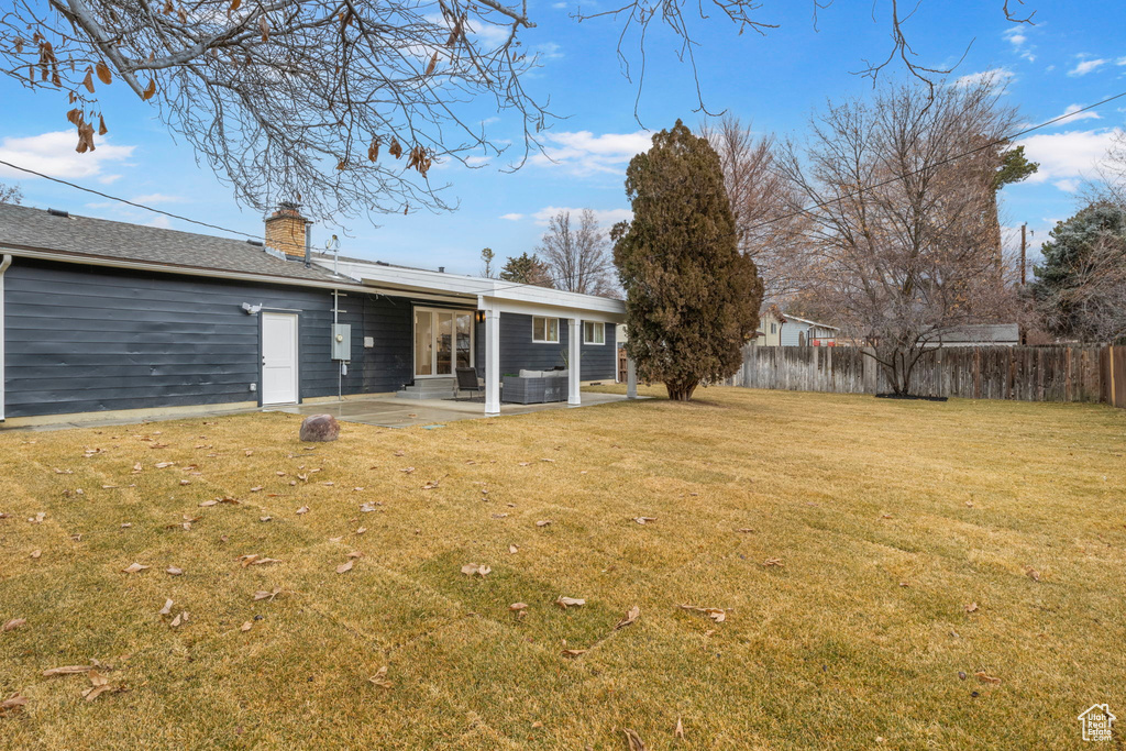 Rear view of house featuring a patio area and a lawn