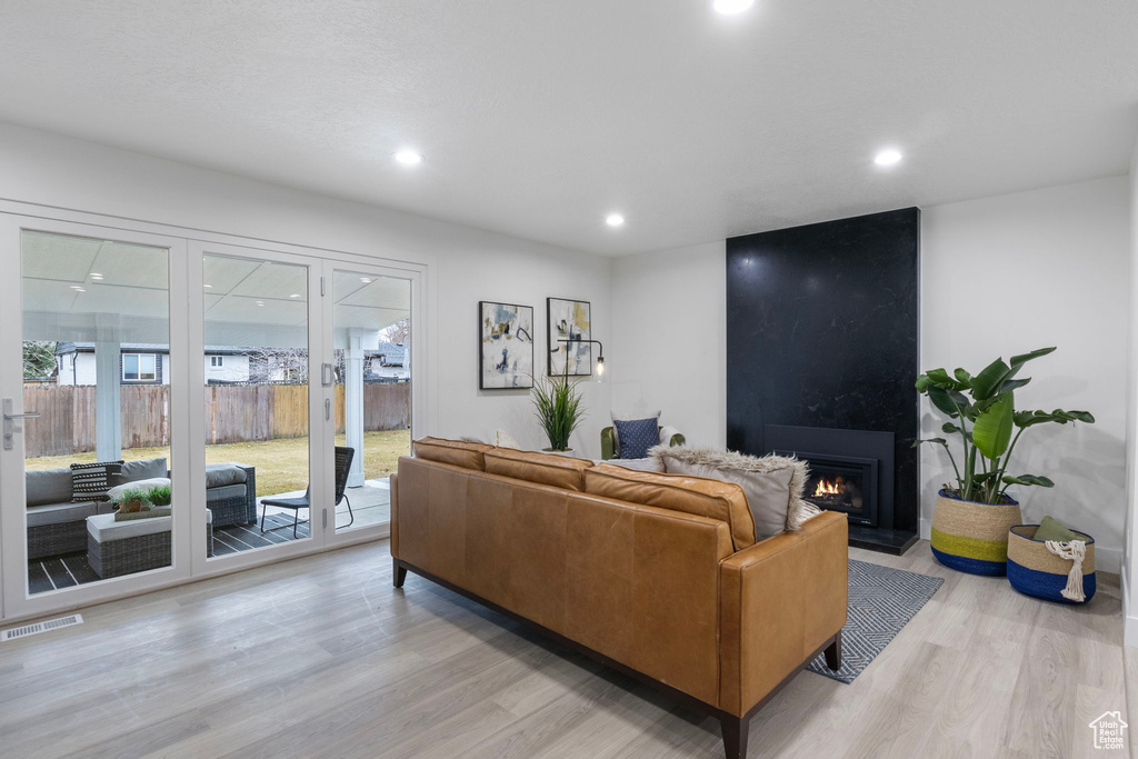 Living room with a large fireplace and light wood-type flooring