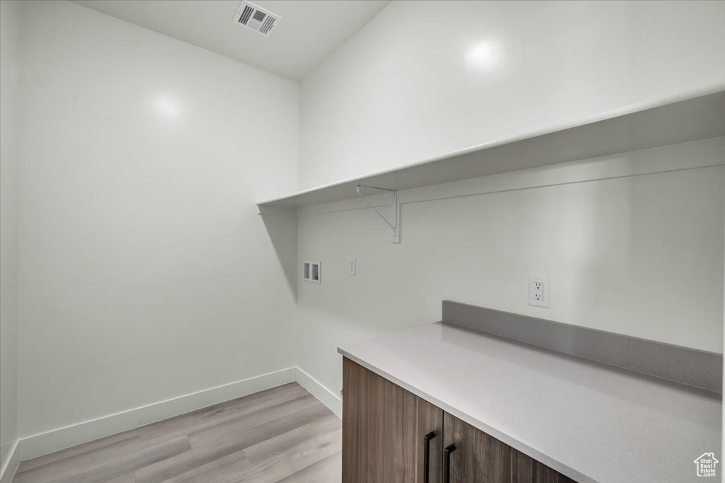 Laundry room featuring washer hookup and light wood-type flooring