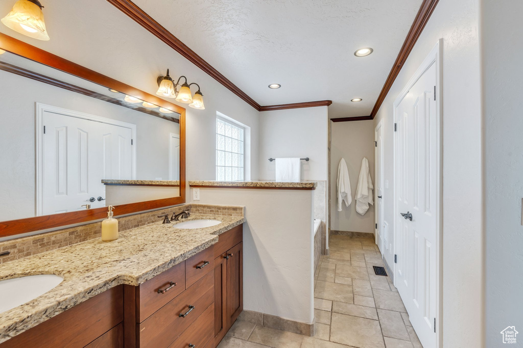 Bathroom with vanity, decorative backsplash, and ornamental molding