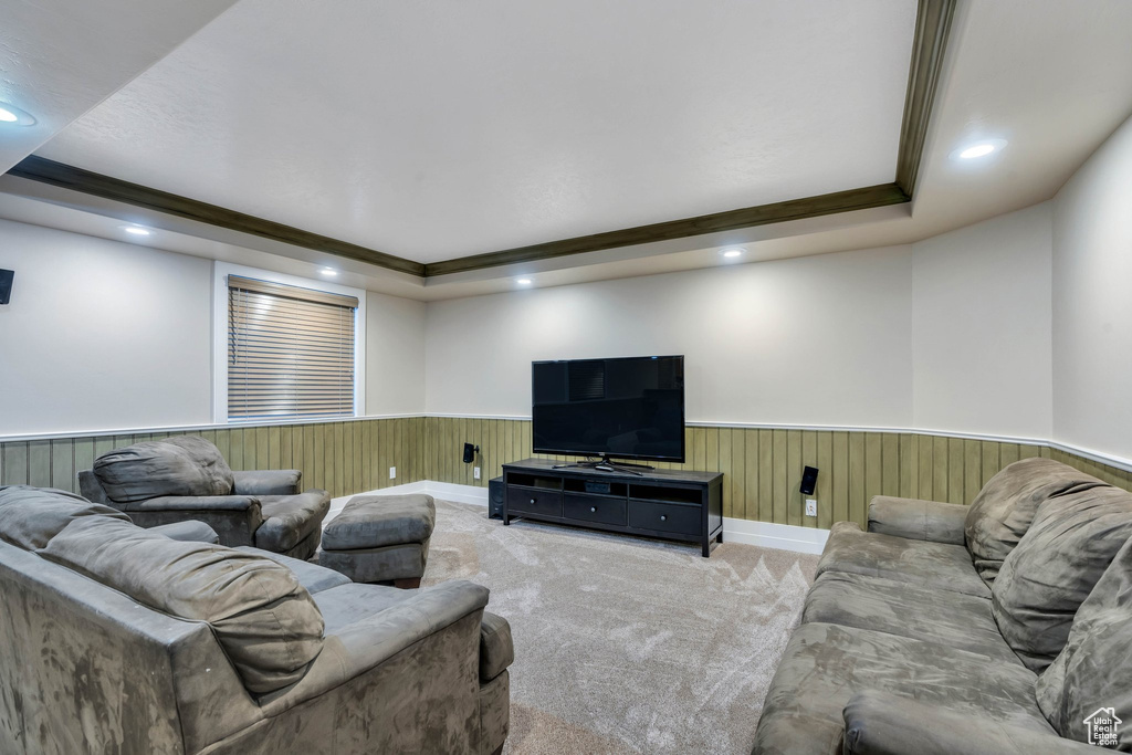 Living room with a tray ceiling, crown molding, and carpet