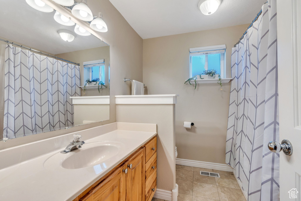 Bathroom featuring tile patterned floors, vanity, and toilet