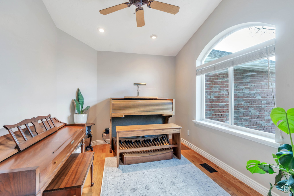 Living area featuring vaulted ceiling, light hardwood / wood-style flooring, and ceiling fan