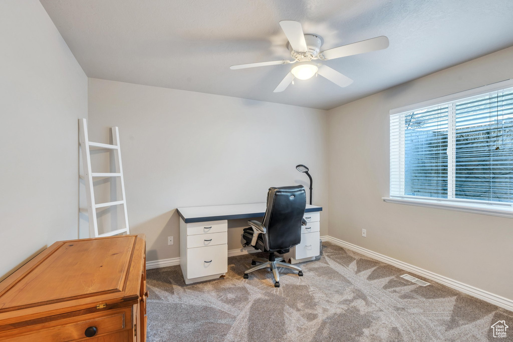 Office space with light carpet and ceiling fan