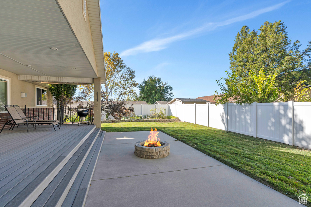 View of patio / terrace with a wooden deck and an outdoor fire pit