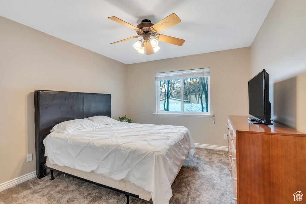 Carpeted bedroom featuring ceiling fan