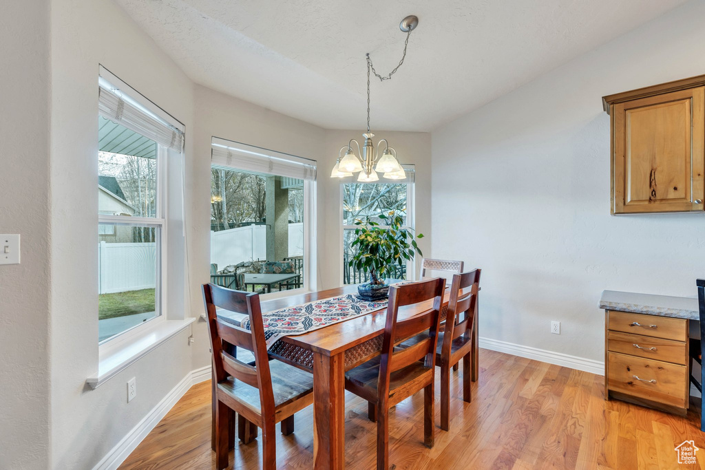 Dining space featuring light wood-type flooring and an inviting chandelier