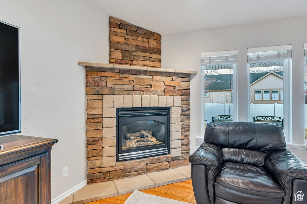 Living room featuring a stone fireplace and light hardwood / wood-style floors