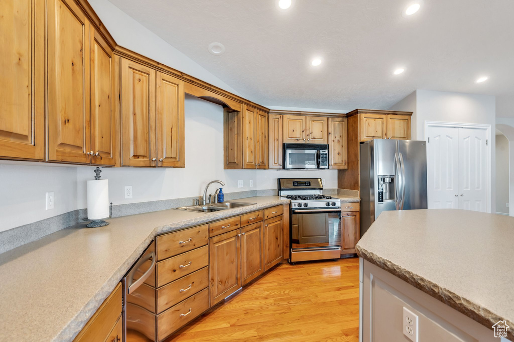 Kitchen with light wood-type flooring, stainless steel appliances, and sink