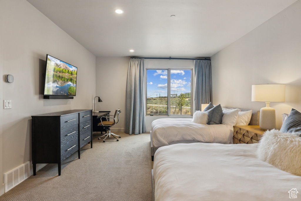 Bedroom with light colored carpet, an office area, recessed lighting, and baseboards