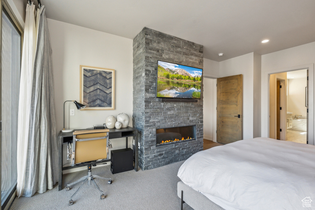 Carpeted bedroom with a fireplace and recessed lighting