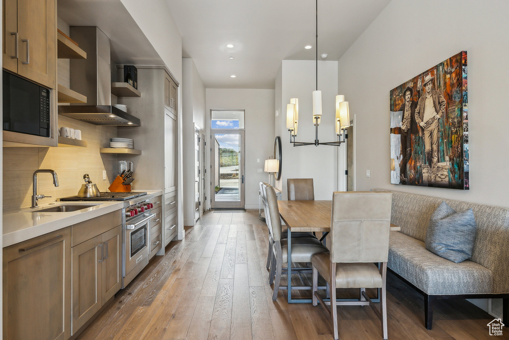 Kitchen with open shelves, a sink, wall chimney range hood, built in microwave, and luxury stove