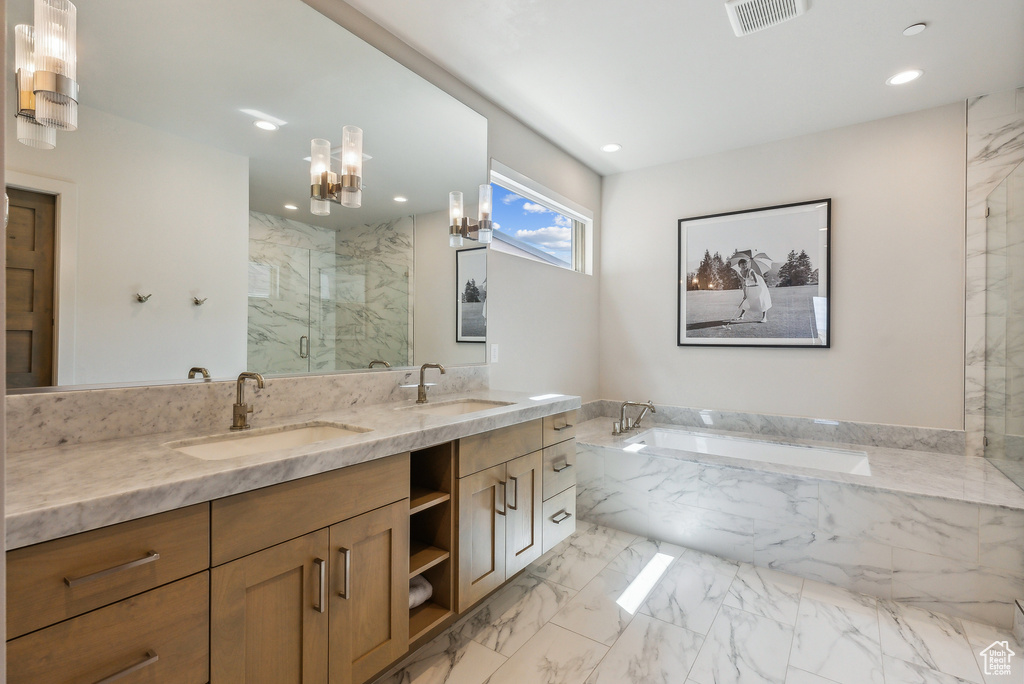Full bathroom with a marble finish shower, double vanity, a bath, a chandelier, and recessed lighting