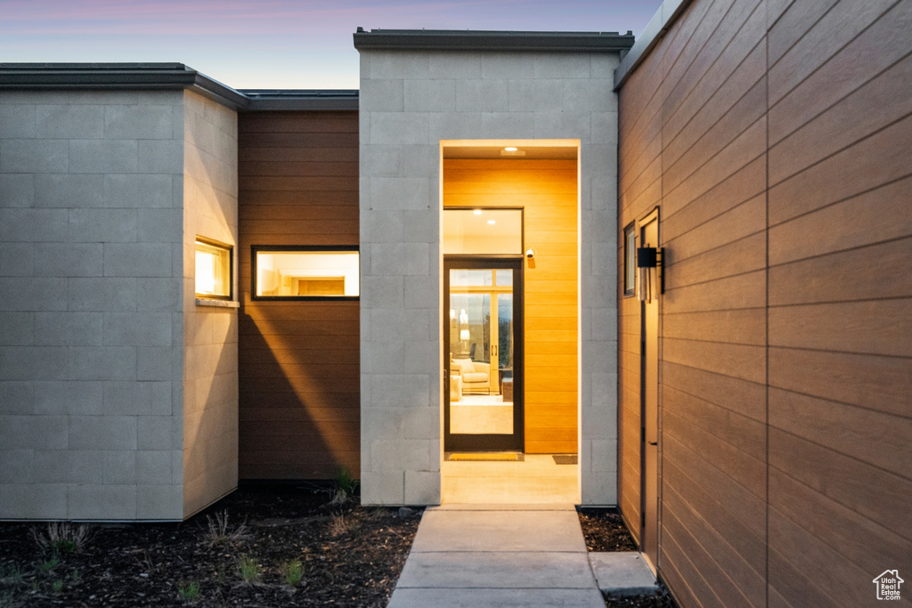 Exterior entry at dusk with concrete block siding