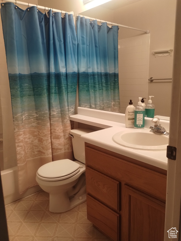Bathroom featuring toilet, vanity, and shower / bath combo