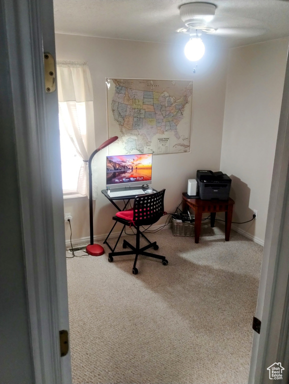 Carpeted home office featuring baseboards