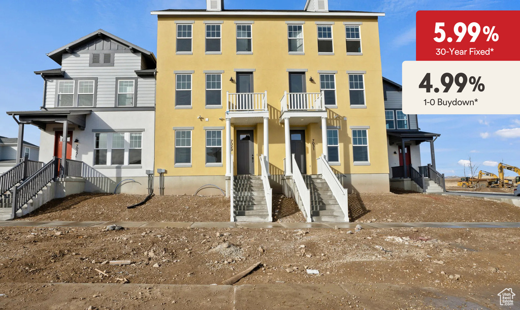 View of front of property with stucco siding and a balcony
