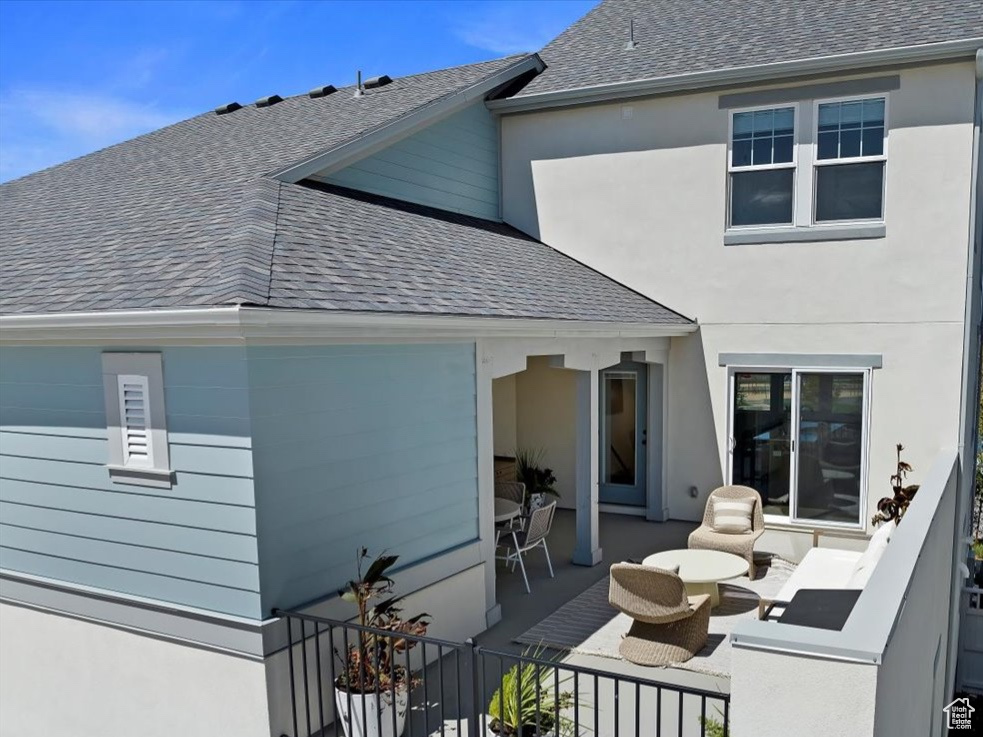 Rear view of house featuring a balcony, outdoor lounge area, and a water view