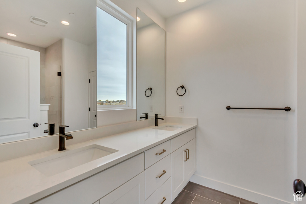 Full bathroom featuring double vanity, tile patterned floors, and recessed lighting