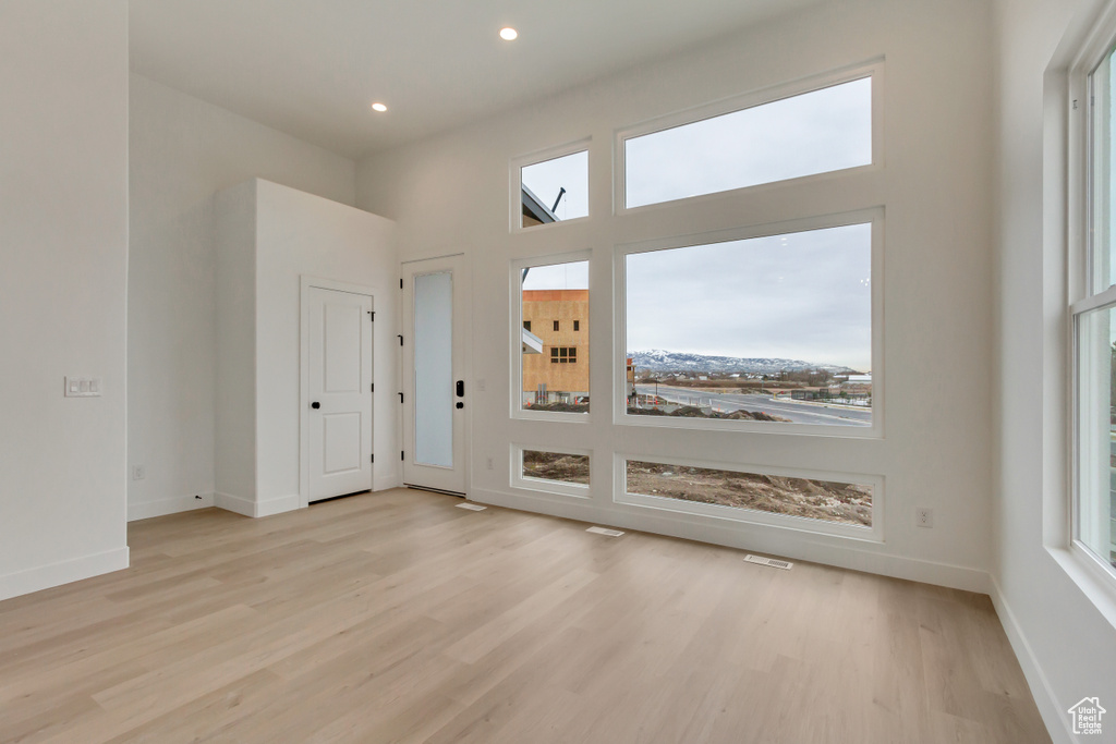 Unfurnished room featuring wood finished floors, healthy amount of natural light, and recessed lighting