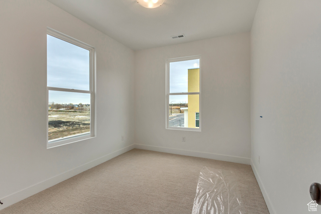 Empty room with light carpet and baseboards