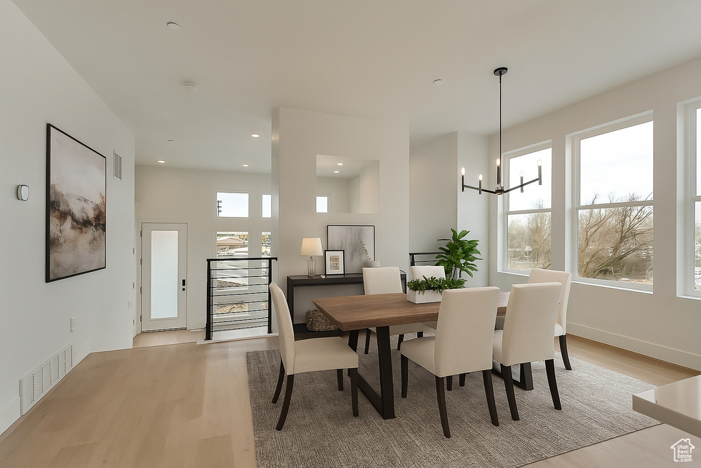 Dining area featuring light wood-type flooring, a chandelier, and recessed lighting