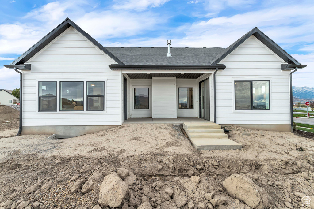 Back of property featuring a patio and roof with shingles