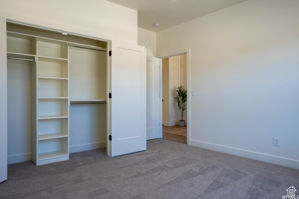 Unfurnished bedroom featuring carpet flooring and a closet