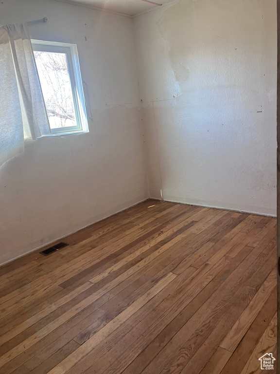 Spare room with visible vents and hardwood / wood-style floors